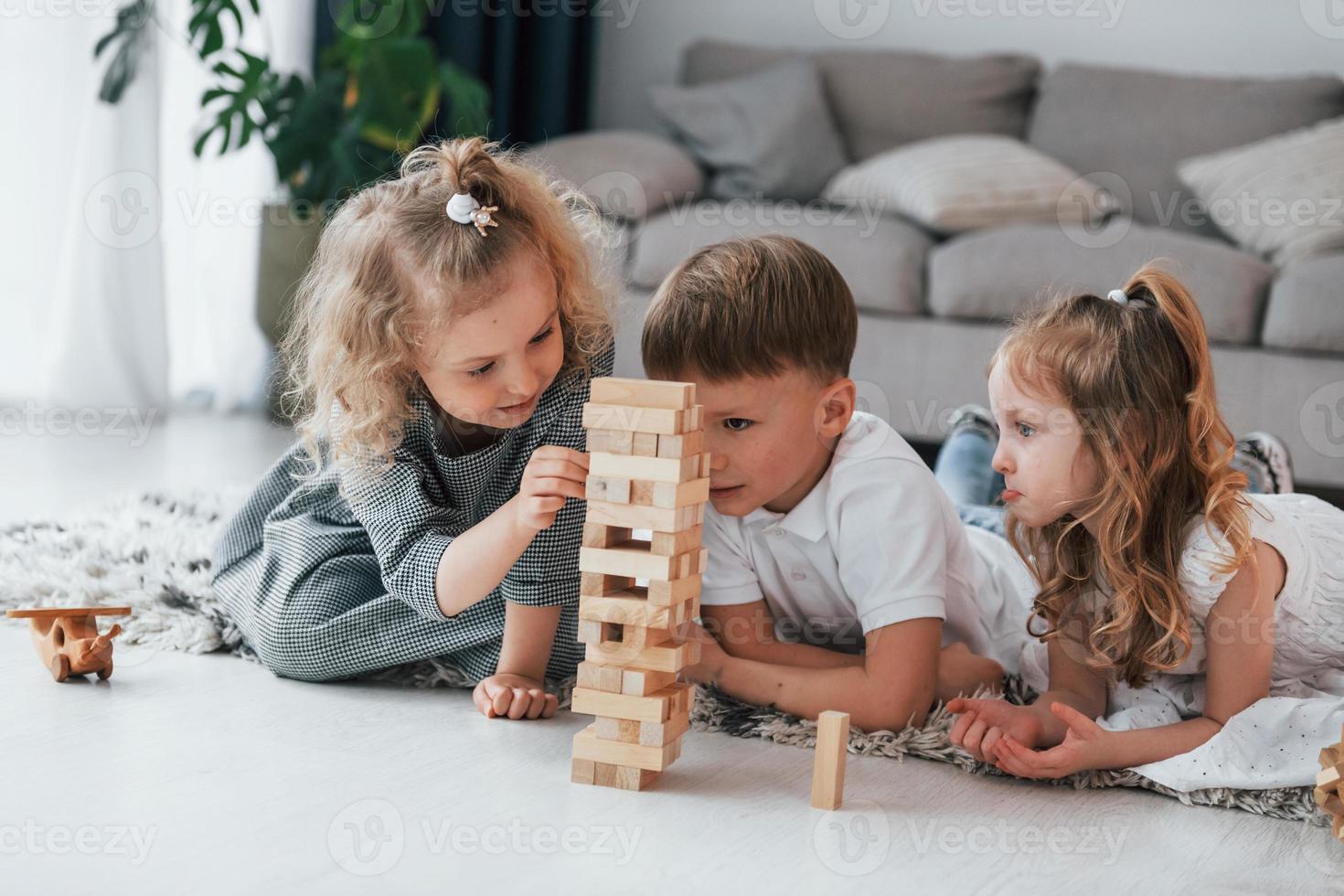jouer au jeu de la tour en bois. groupe d'enfants est ensemble à la maison pendant la journée photo