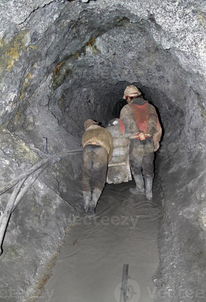 les mineurs se frayent un chemin à travers un puits dangereusement instable dans la montagne cerro rico. photo