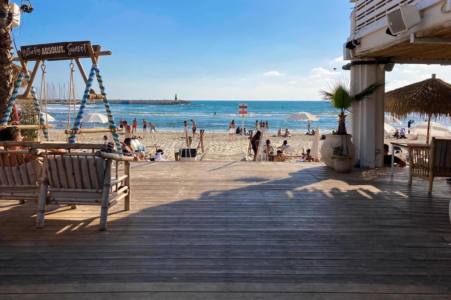 tel aviv, israël , 15 mai 2022. restaurant de plage en plein air avec des gens se reposant sur la plage photo