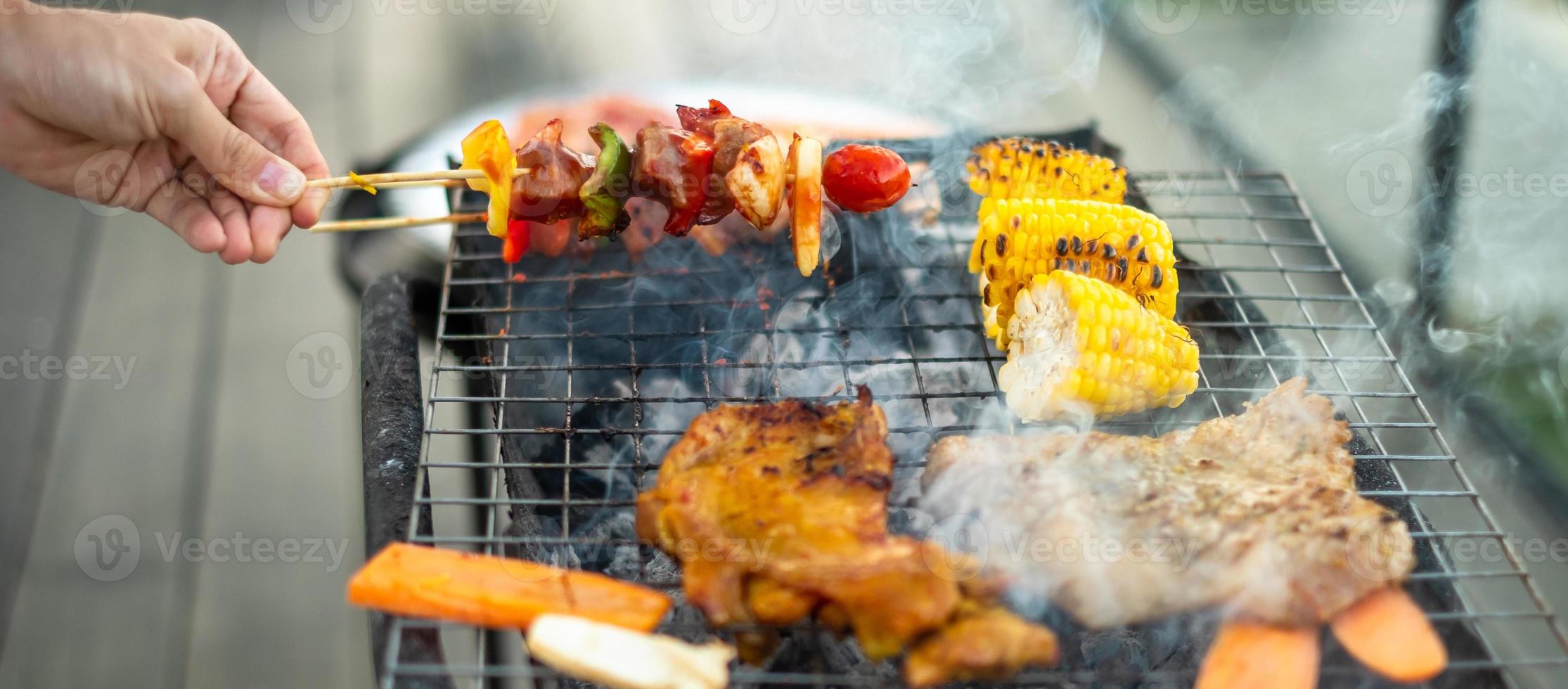 délicieuse viande grillée avec fumée, barbecue avec légumes en plein air. barbecue, fête, style de vie et concept de pique-nique photo