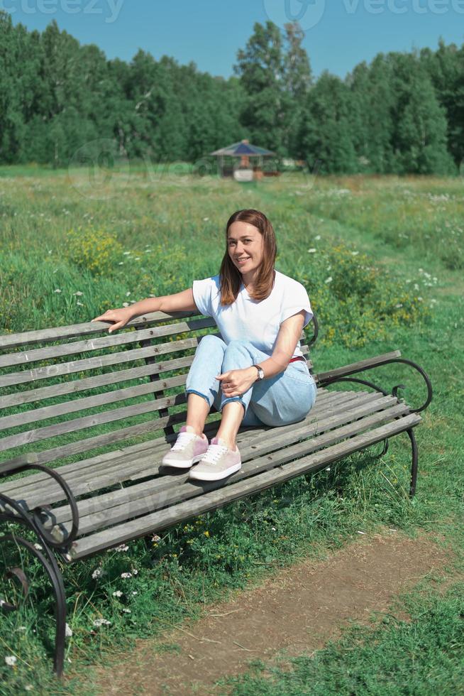 heureuse femme d'âge moyen caucasienne assise sur un banc photo