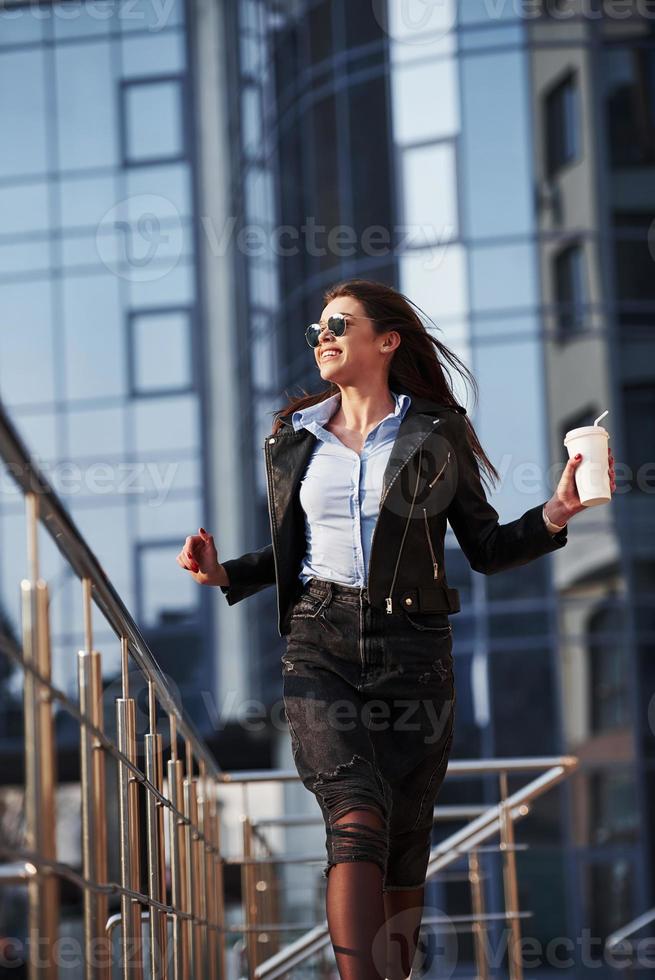 appelez vos amis, il fait un temps magnifique là-bas. jeune belle fille en vêtements chauds se promène dans la ville le week-end photo