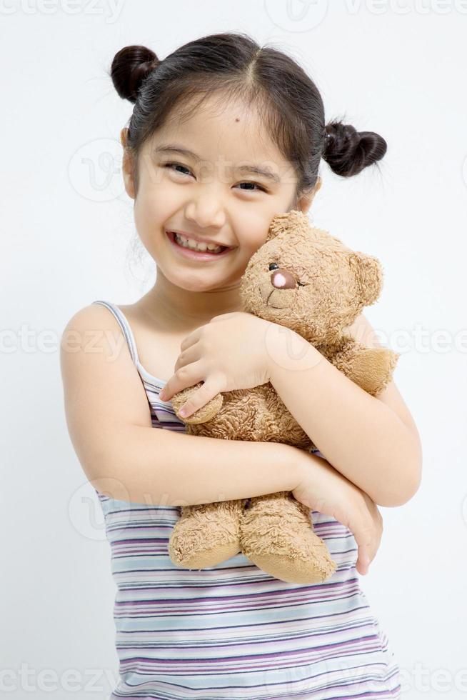 jolie fille jouant avec ours poupée photo