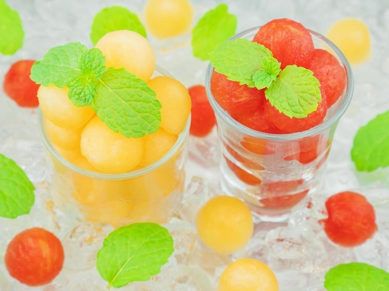 petite sphère en forme de cantaloup et de pastèque dans un verre à décor de menthe et de glace photo