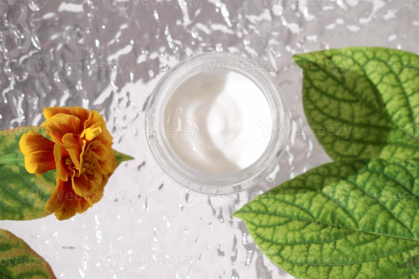 crème de protection du visage pour la saison froide. soins visage hydratants, thérapie anti-âge et anti-rides. vue de dessus. décor d'automne, fleur et feuilles d'oranger. photo