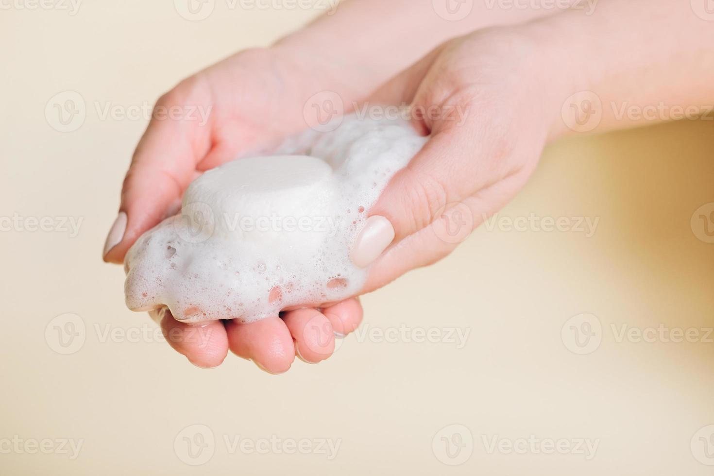 barre solide de shampooing dans les mains de la femme avec de la mousse. autre type de shampoing. produit d'auto-soin écologique. cosmétiques sans emballage plastique, eco friendly, zéro déchet photo