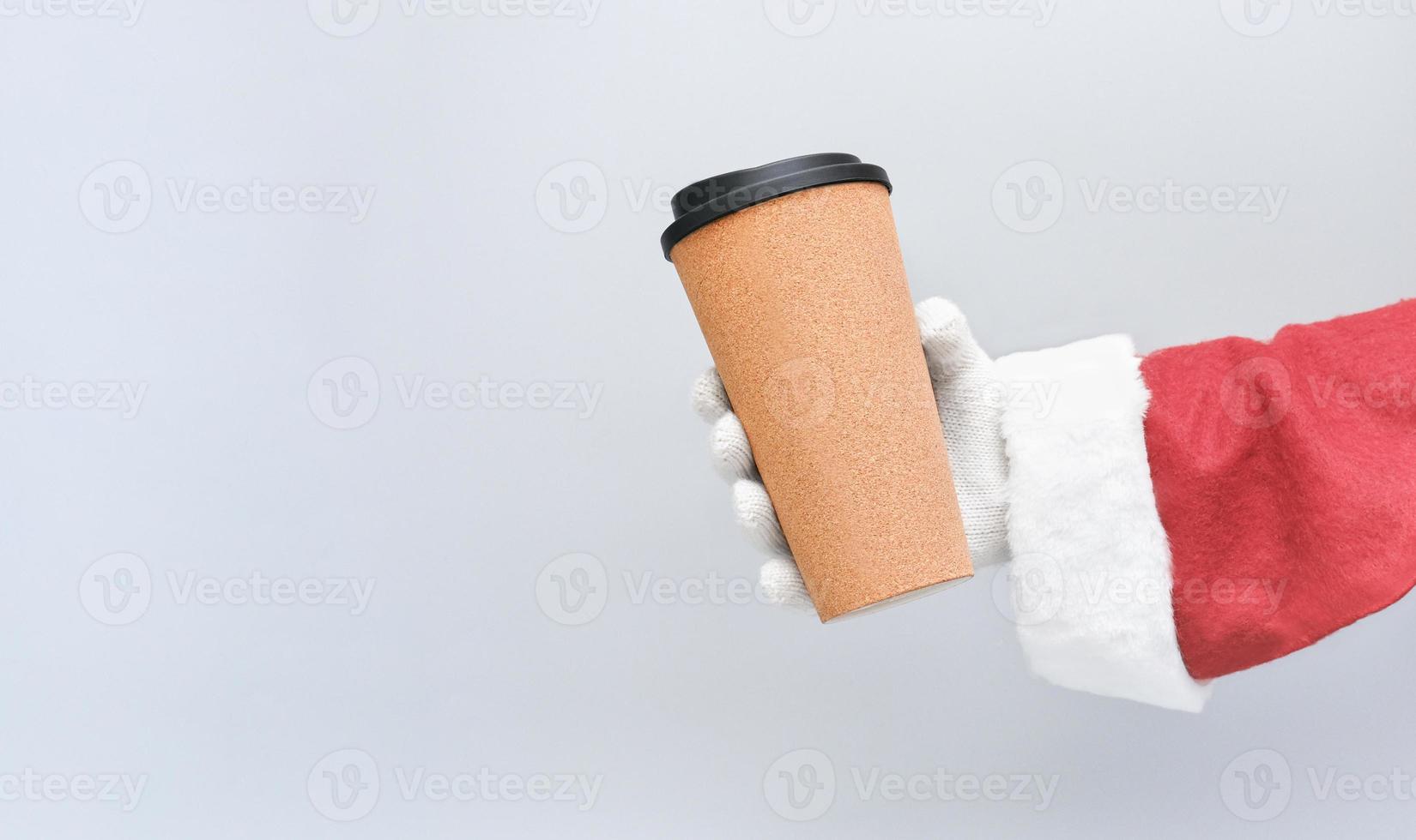 café de noël. la main du père noël tenant une tasse de café à emporter. photo