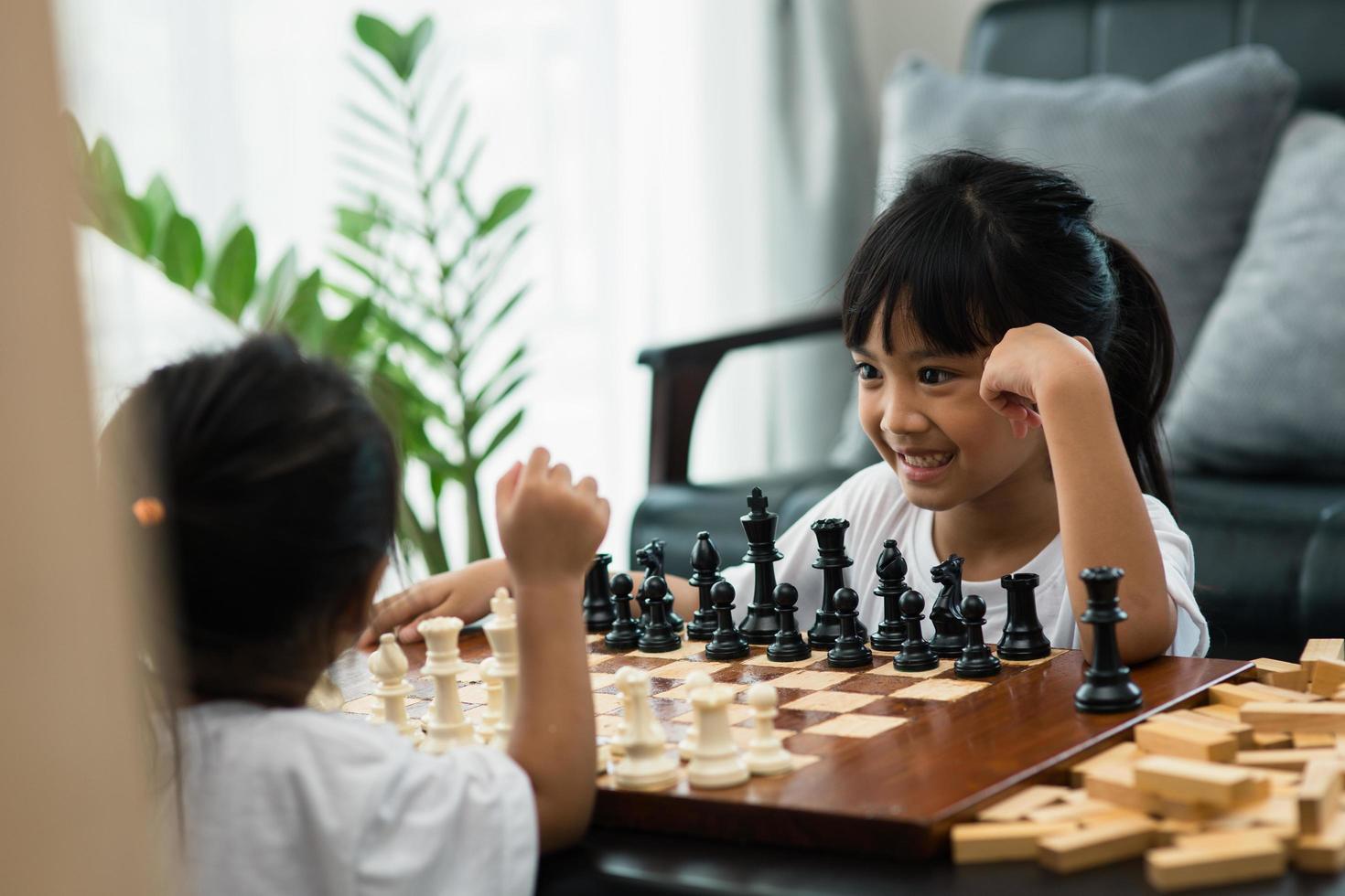 deux enfants mignons jouant aux échecs à la maison photo