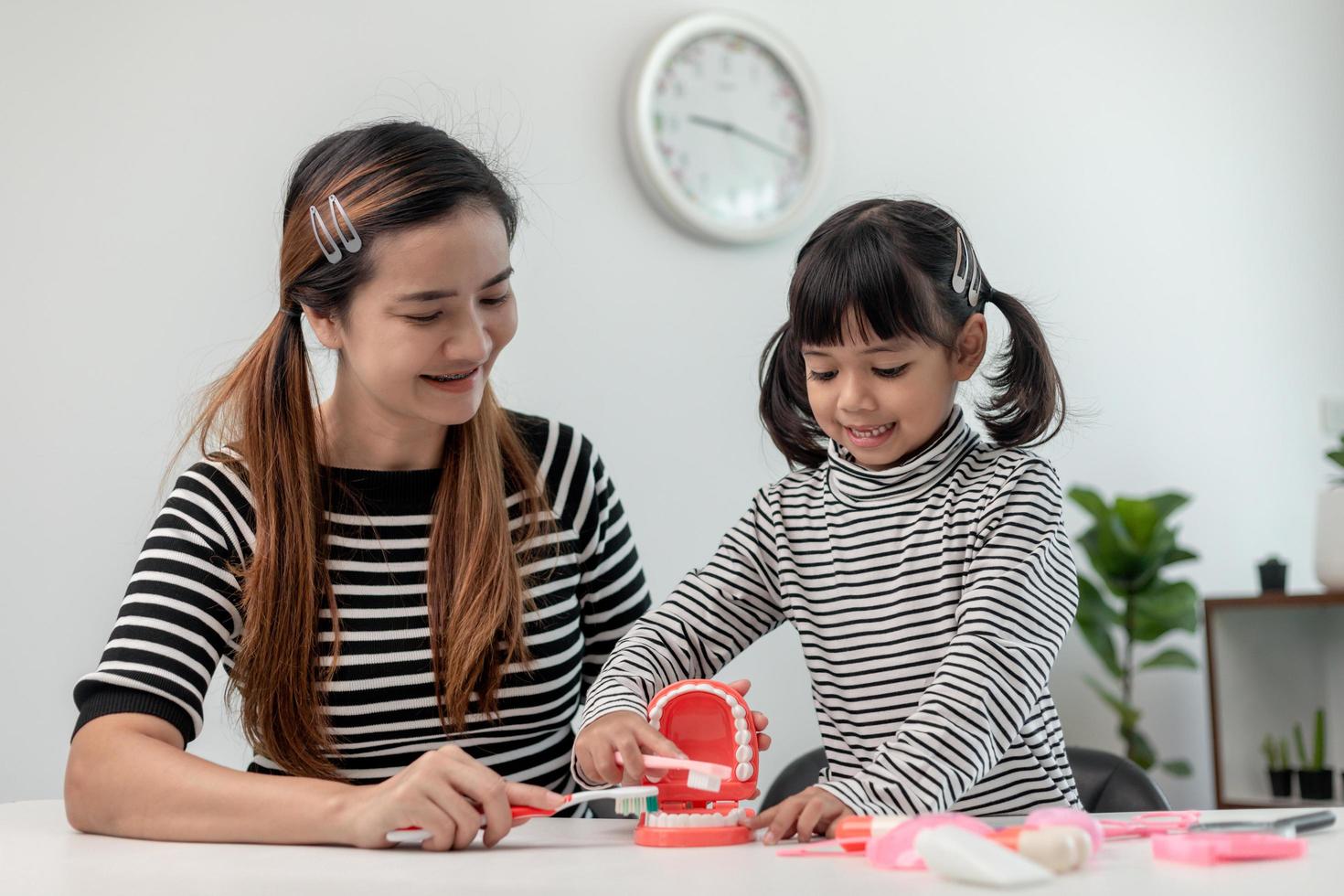 mère enseignant fille enfant se brosser les dents à la maison photo