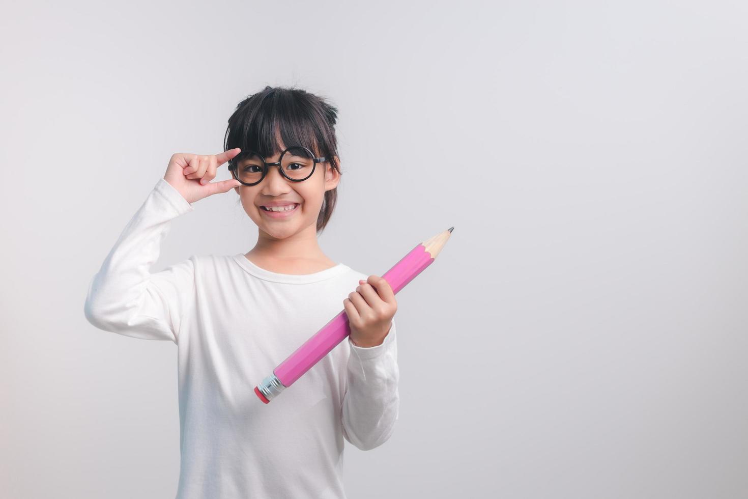 jeune fille excitée tenant de gros crayons dans ses mains. retour à l'école. photo