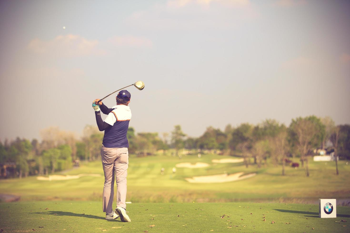 les golfeurs frappent un vaste parcours de golf en été.couleur vintage photo