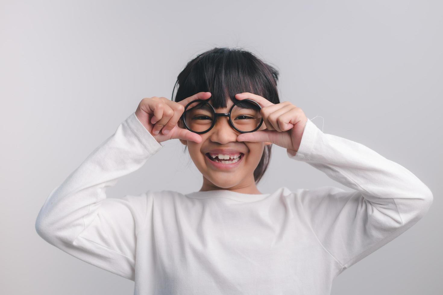 concept d'éducation, d'école et de vision - jolie petite fille souriante à lunettes noires photo