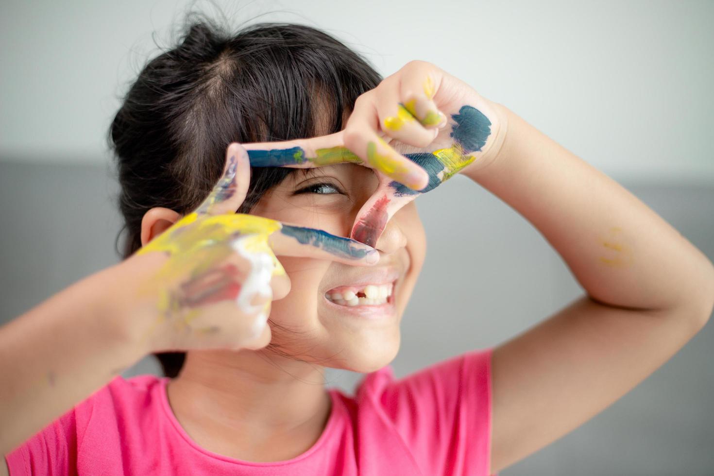 concept d'éducation, d'école, d'art et de peinture - petite étudiante montrant des mains peintes photo