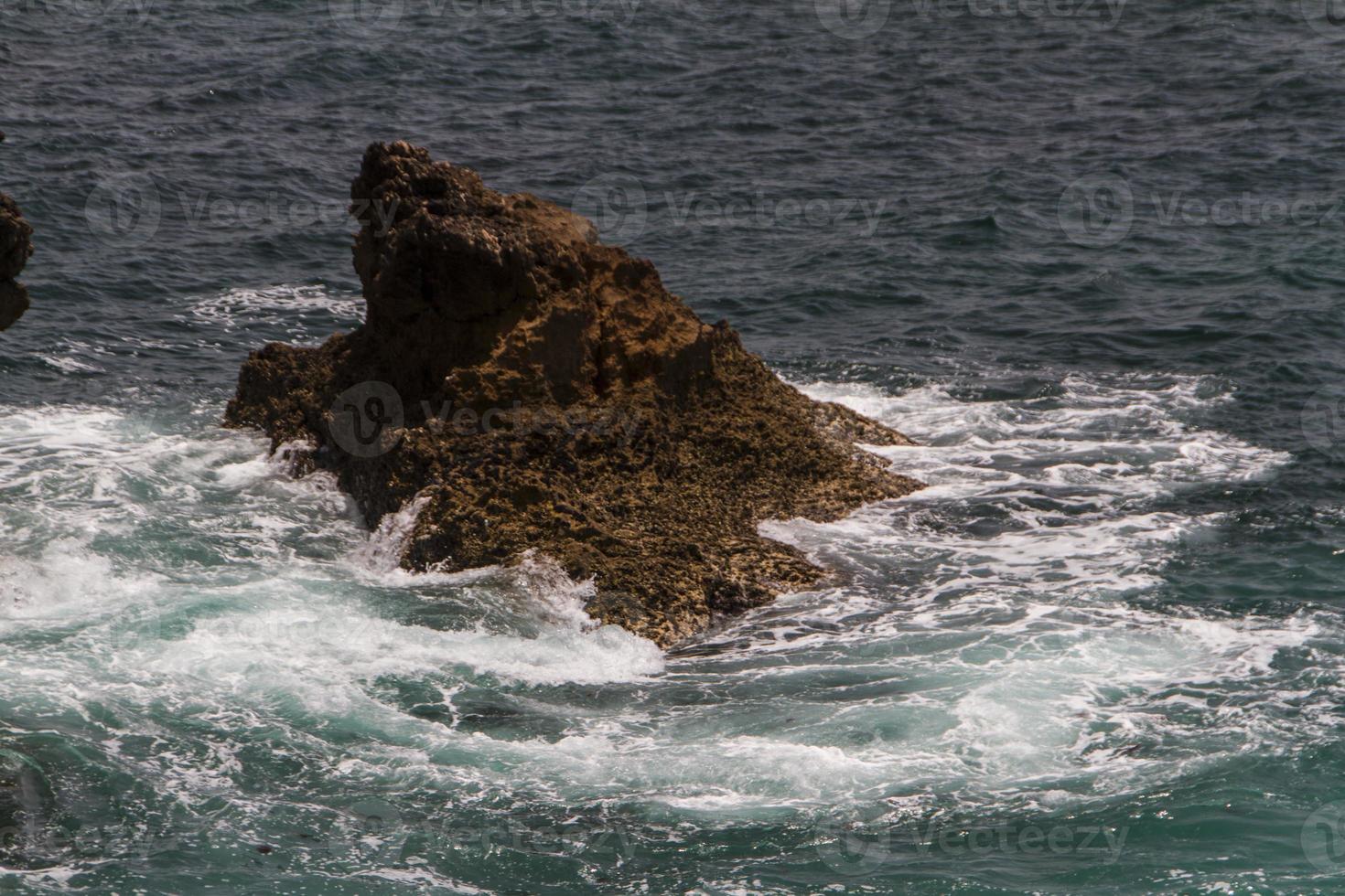 les vagues se battent sur la côte rocheuse déserte de l'océan atlantique, le portugal photo