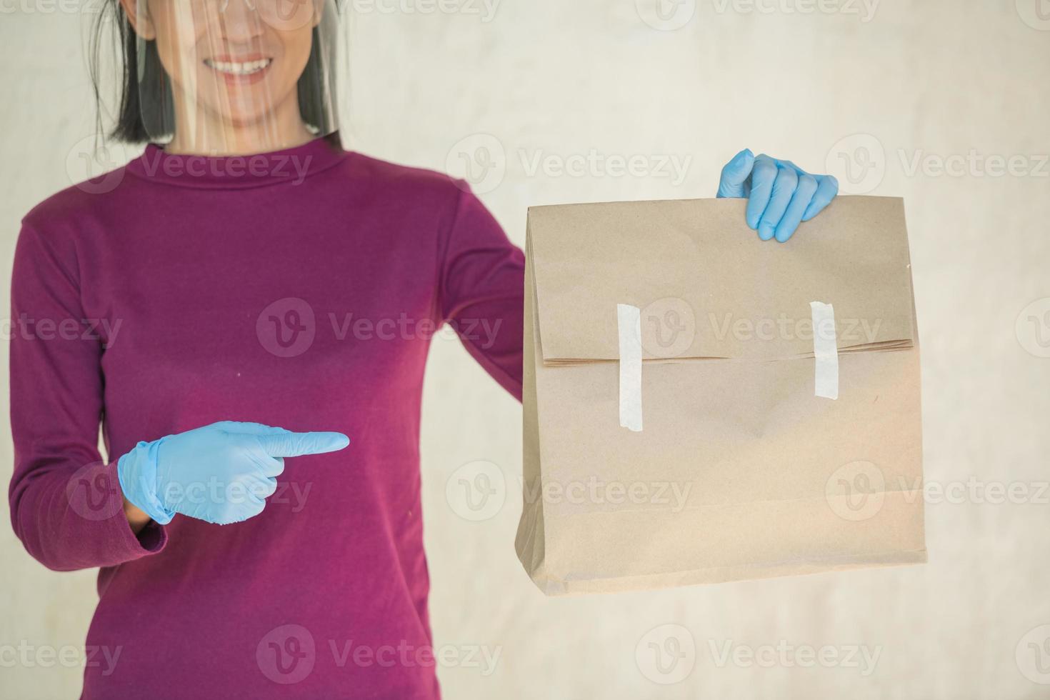 gros plan les mains coupées tiennent un sac en papier blanc vide clair marron pour emporter isolé sur fond blanc. maquette de modèle d'emballage. notion de service de livraison. espace de copie. espace publicitaire. photo