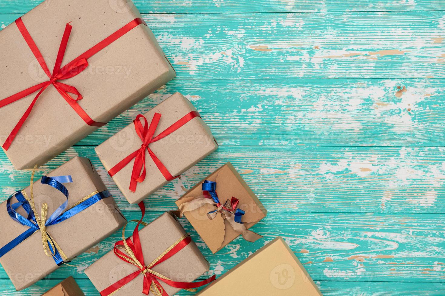 fond de magasinage de cadeaux de vacances de noël. vue d'en haut avec espace de copie. boîtes à cadeaux en papier kraft attachées à partir d'une corde sur fond bleu, vue de dessus. composition à plat pour anniversaire. photo