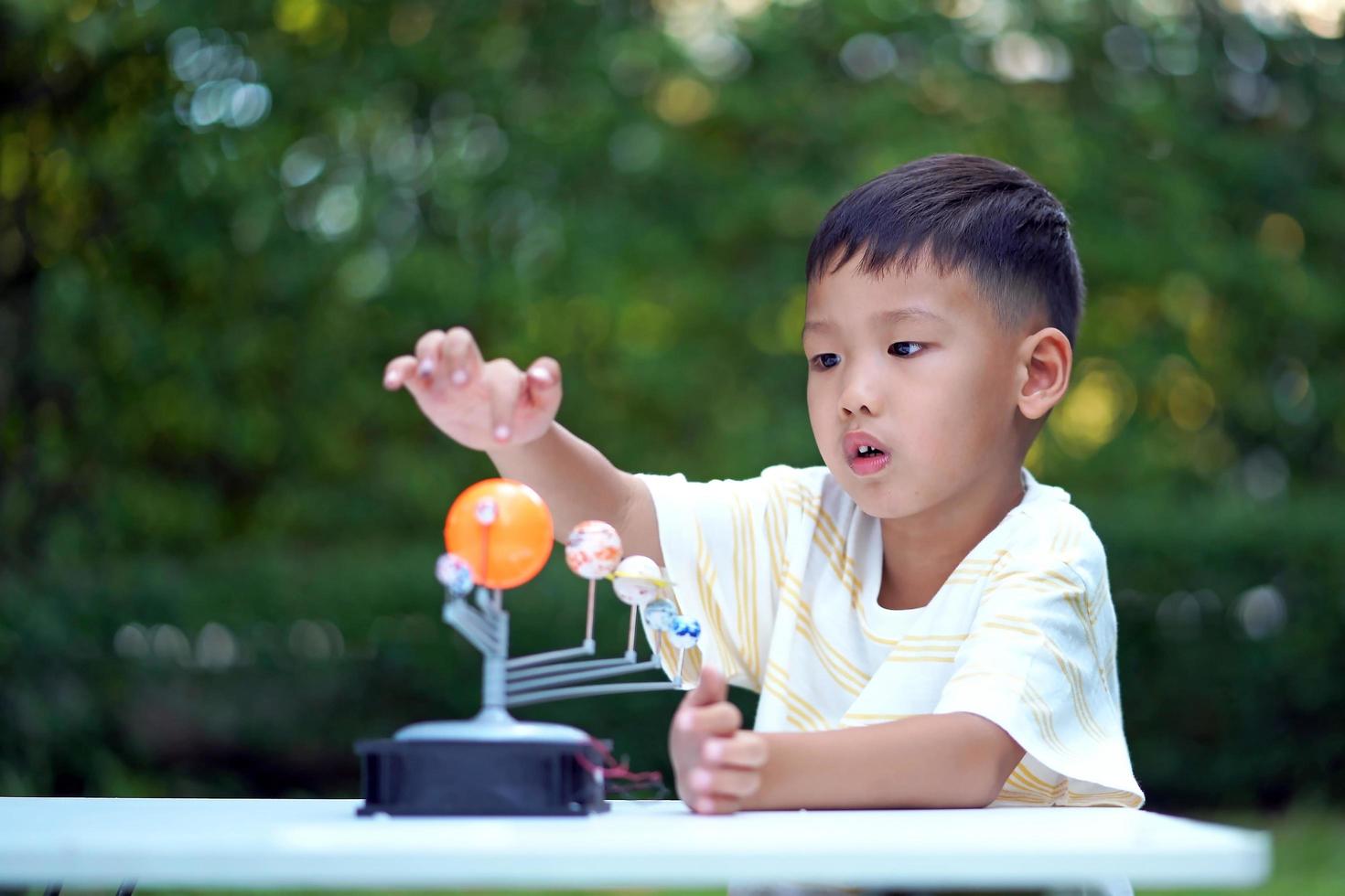 jouets du système solaire vivant pour garçon asiatique, équipement d'apprentissage à domicile, lors d'un nouveau changement normal après le coronavirus ou la situation de pandémie post-épidémie de covid-19 photo