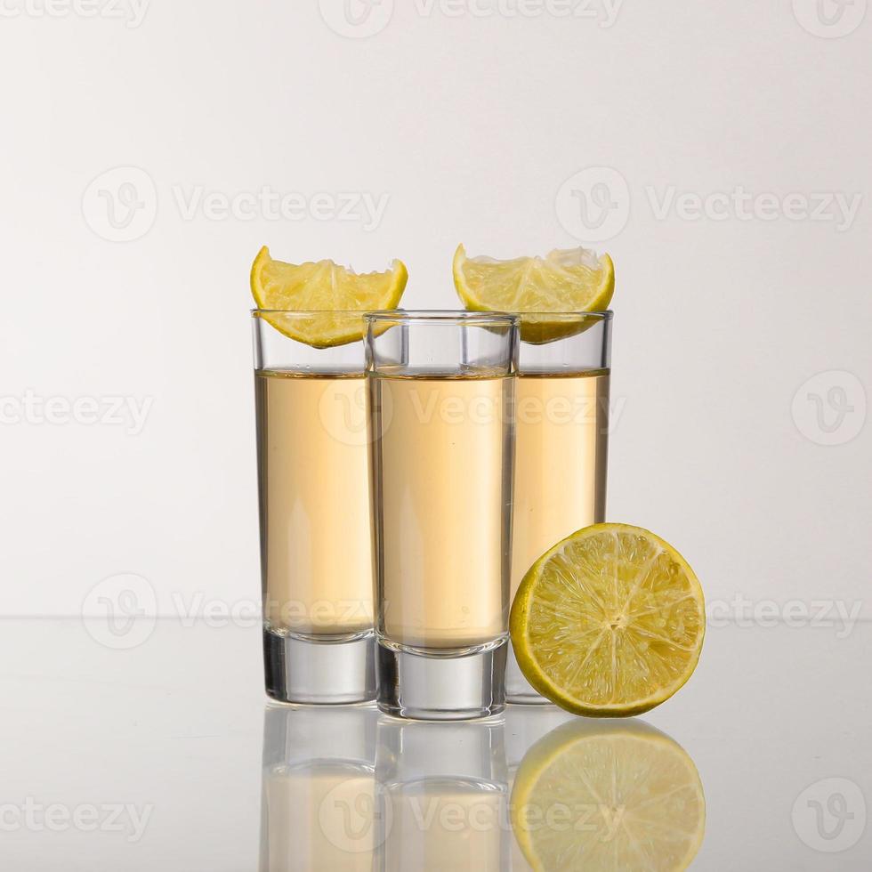 trois coups de tequila or avec de la chaux isolé sur fond blanc photo