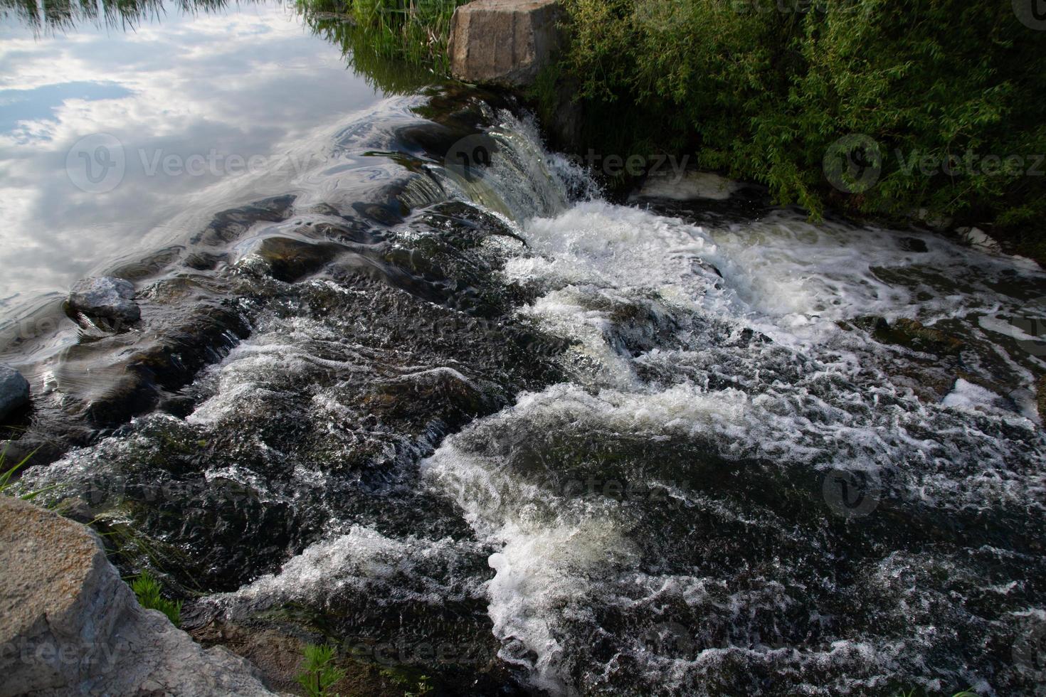 une petite cascade de rivière par une belle journée d'été ensoleillée. photo