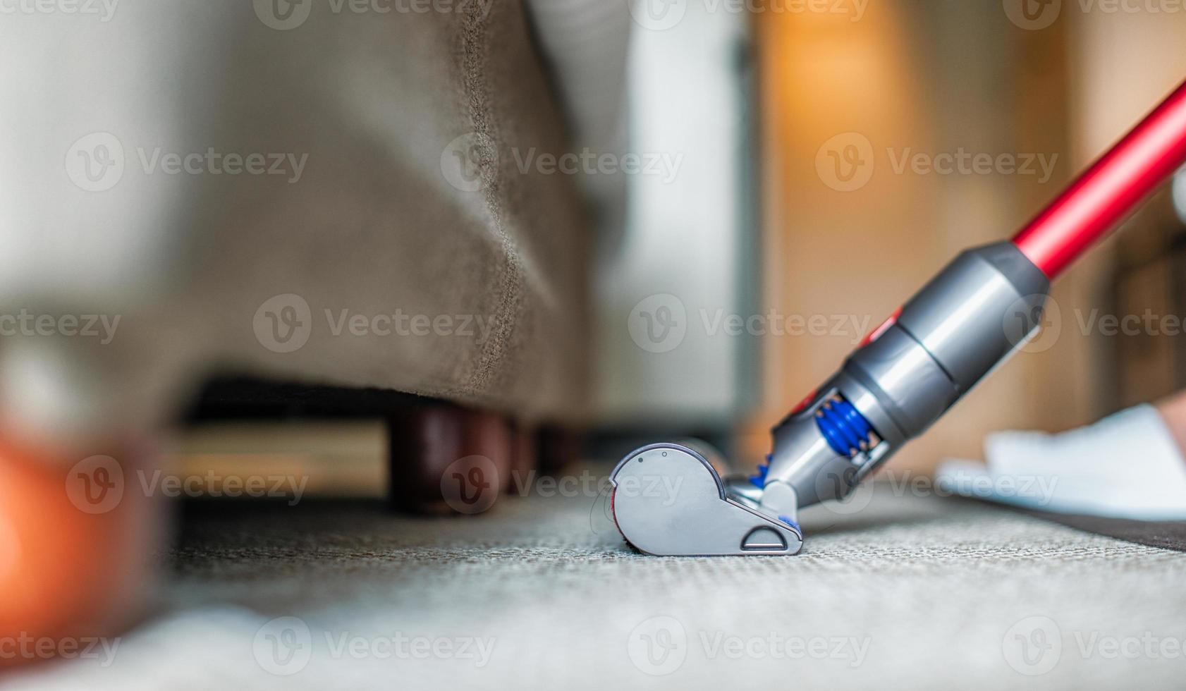 aspirateur moderne tout en passant l'aspirateur. femme à l'aide d'un aspirateur tout en nettoyant le tapis dans la maison. concept de nettoyage de maison. photo