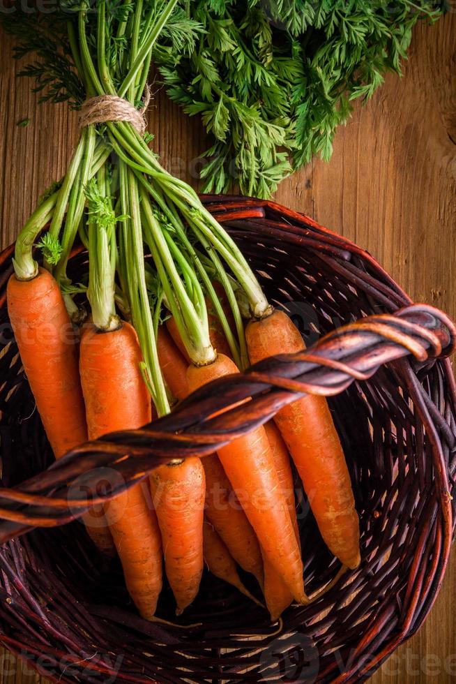 Bouquet de carottes fraîches dans le panier photo