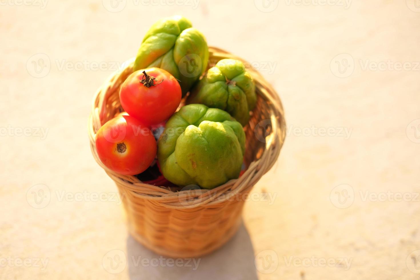 tomates fraîches et citrouille dans un panier en feuilles de bambou. photo