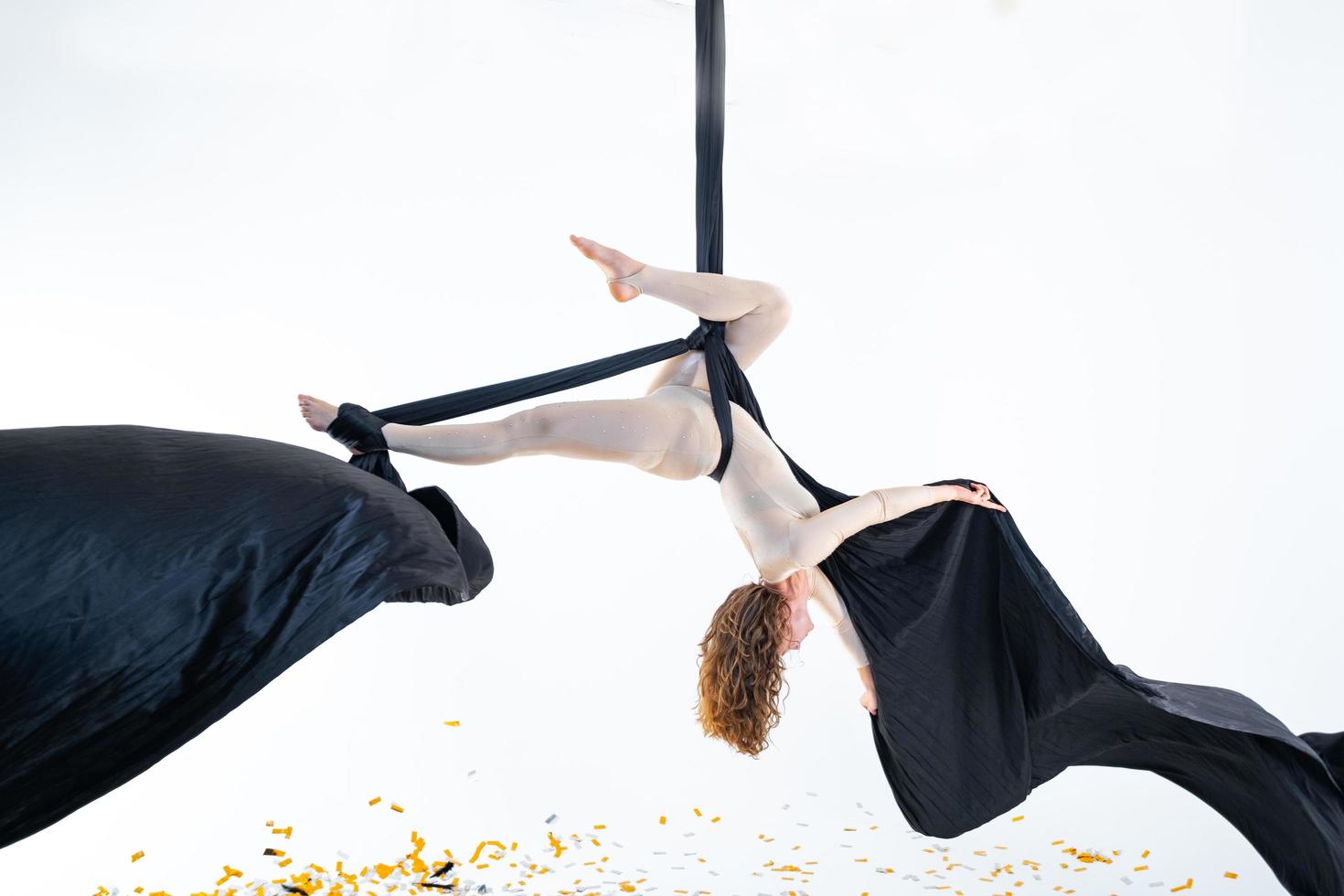 femme suspendue en soie aérienne en studio blanc photo