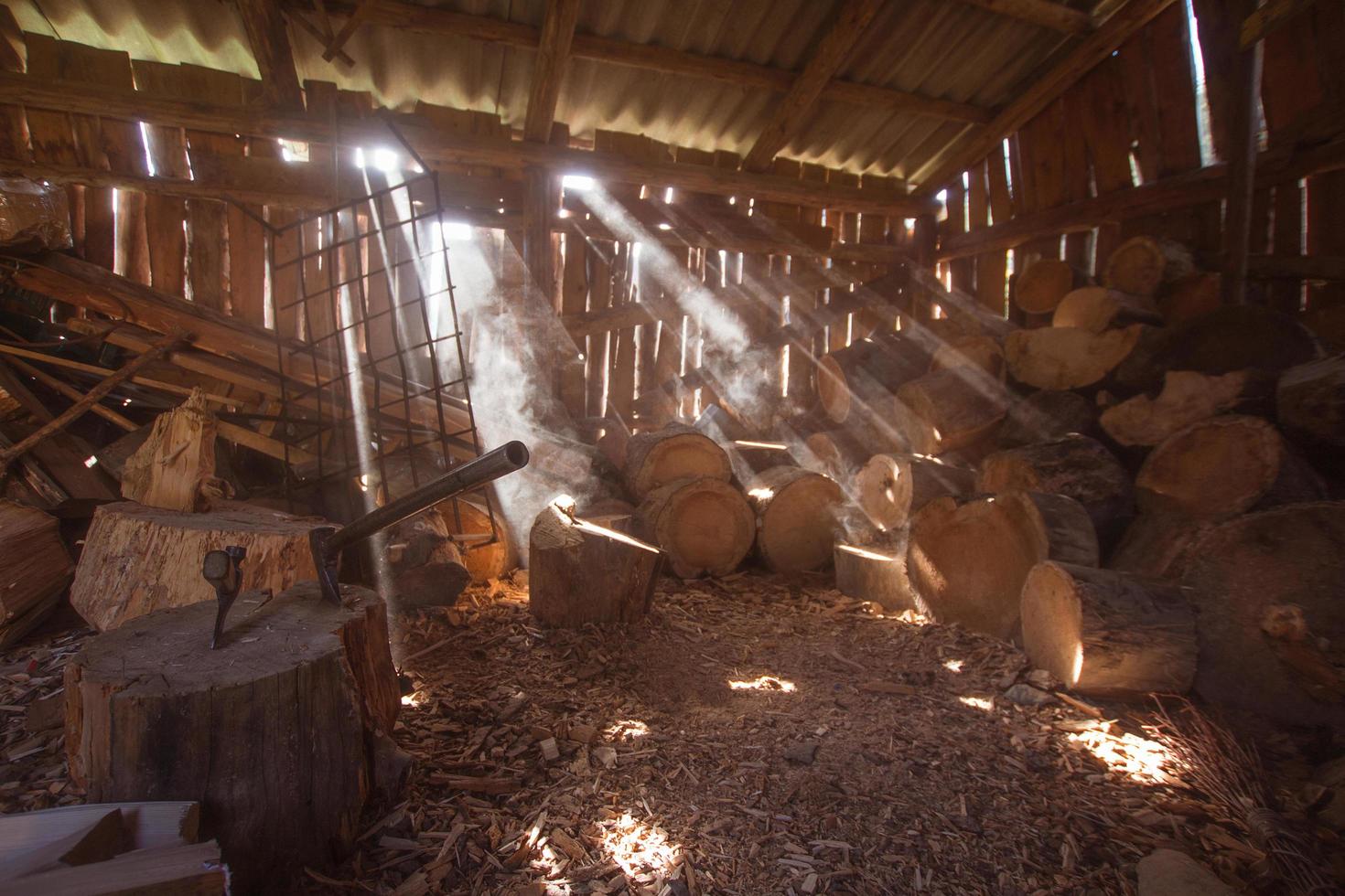 grange de bûcheron avec bois de chauffage et haches, lumière cinématographique photo