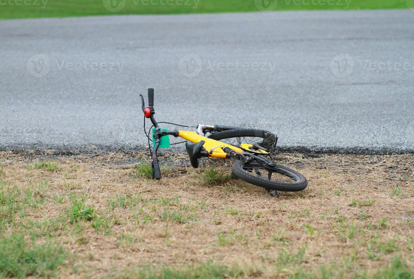 vélo jaune tombé à côté de la rue photo