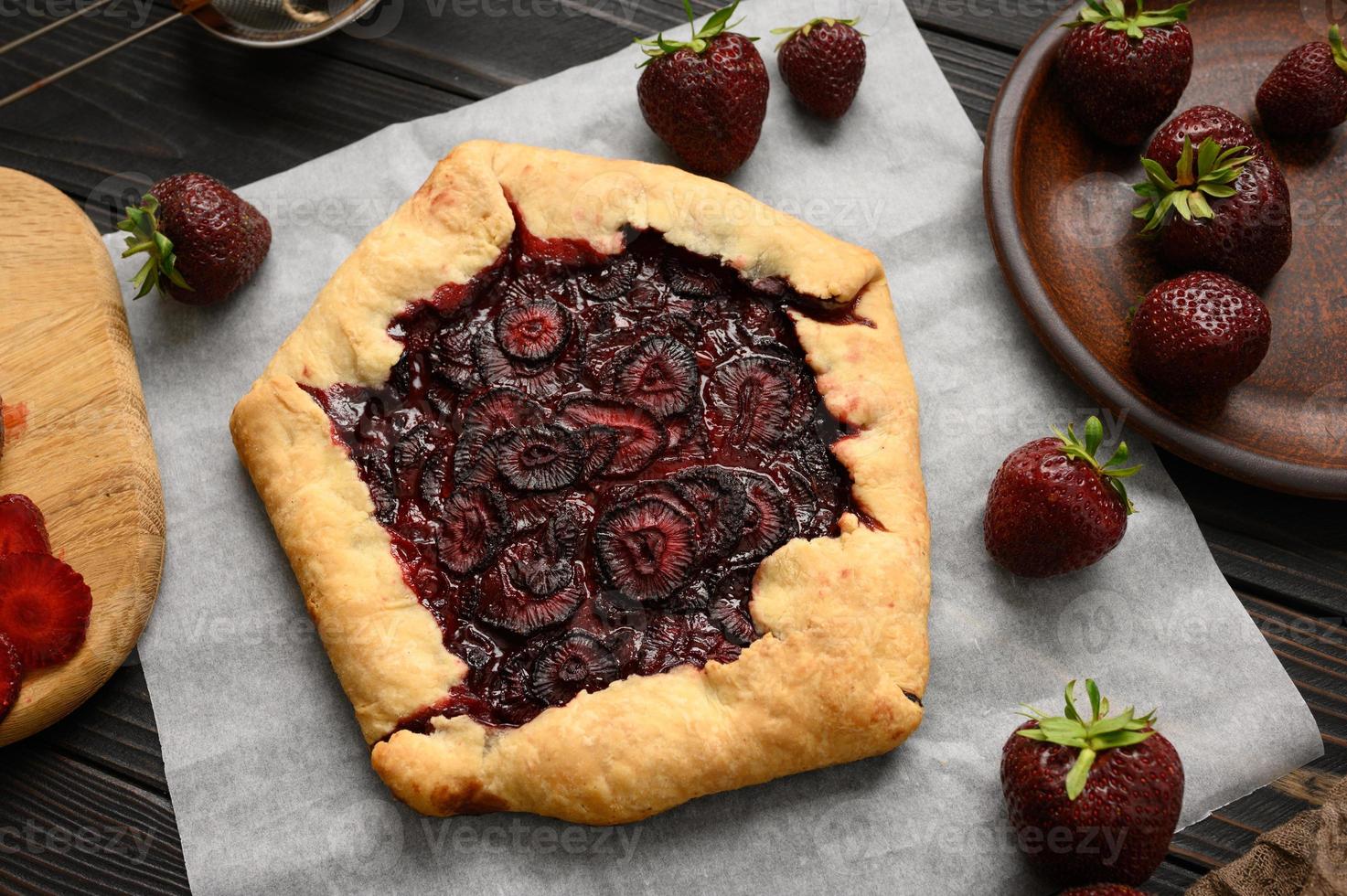 galette aux fraises sur fond de bois foncé. fait maison photo