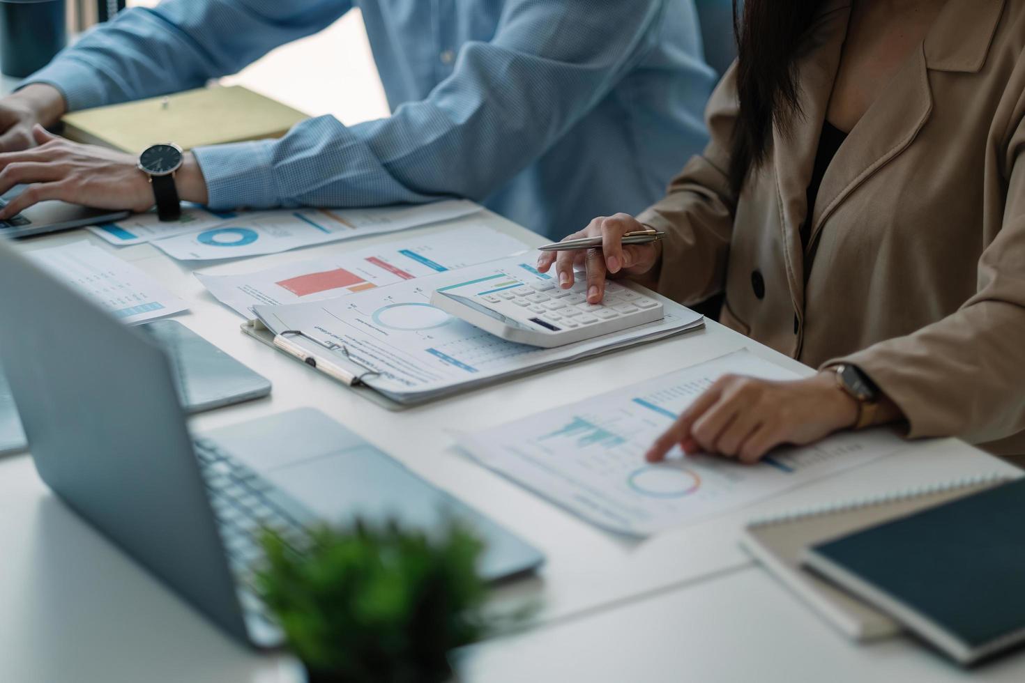 main de comptable de femme d'affaires travaillant sur la calculatrice pour calculer le rapport de données financières, le document de comptabilité et l'ordinateur portable au bureau, concept d'entreprise photo