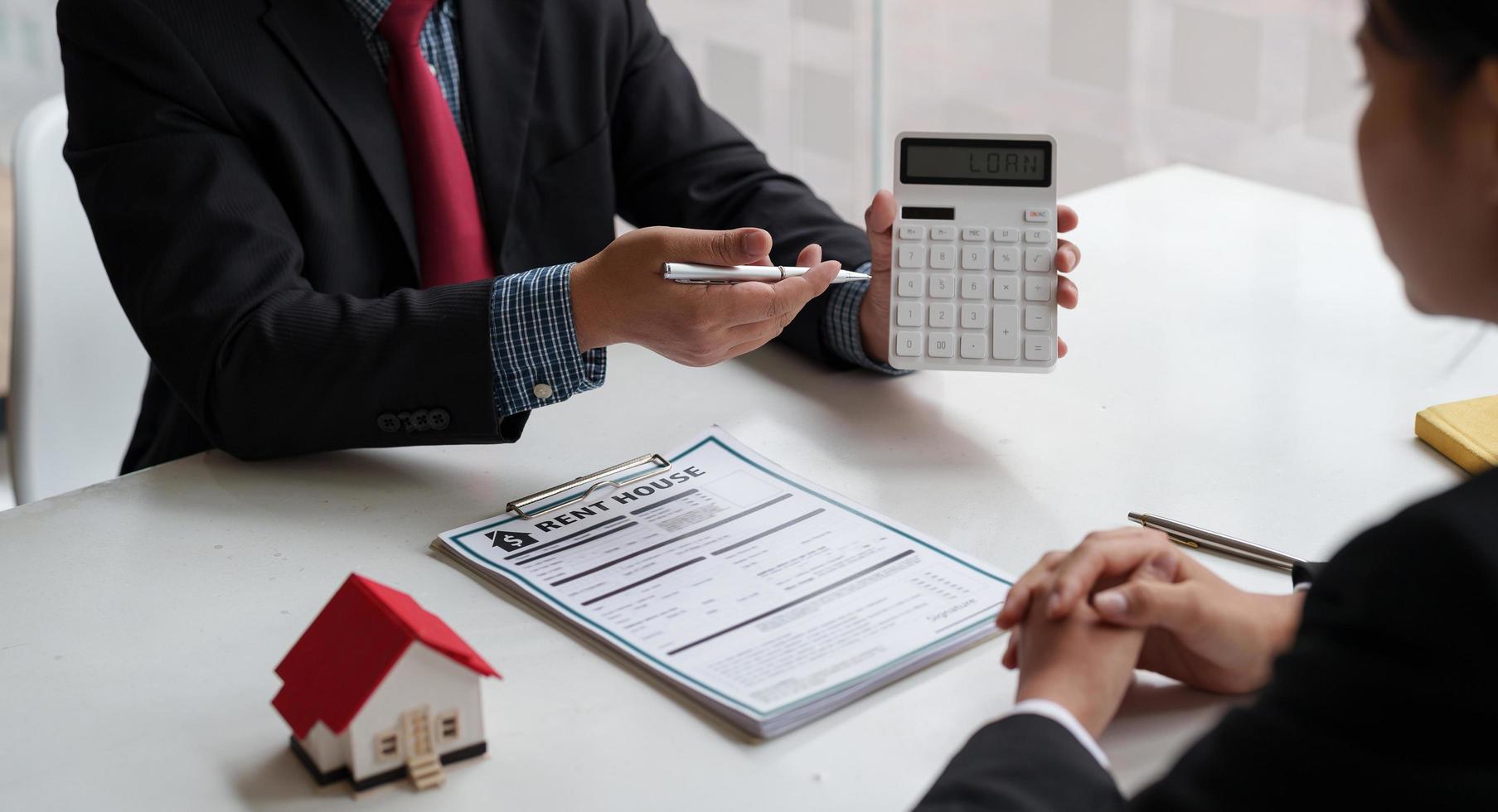 L'agent immobilier a parlé des termes du contrat d'achat de maison pour signer les documents nécessaires à la conclusion légale du contrat, de la vente de maisons et du concept d'assurance habitation. photo