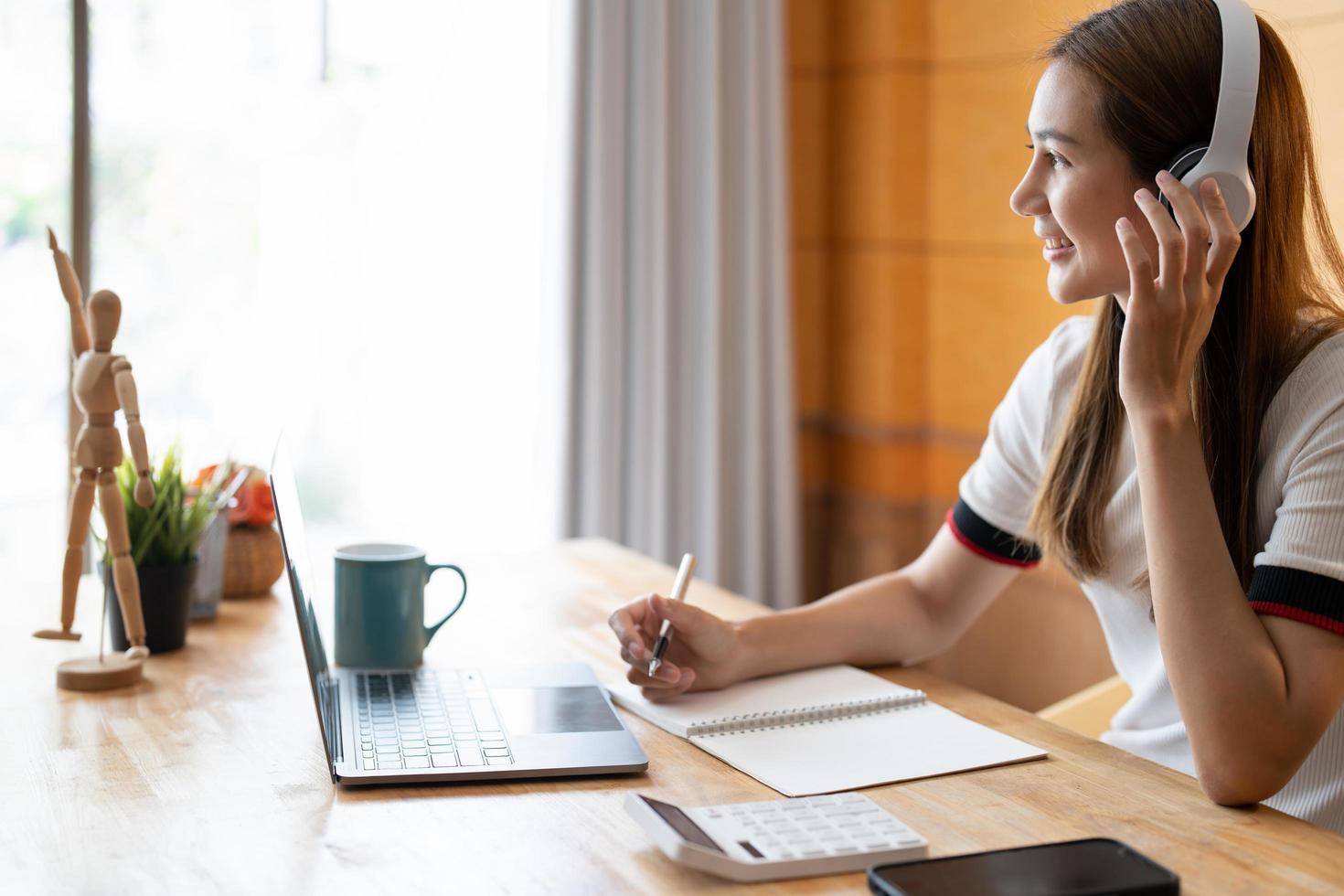 jeune femme asiatique écrivant des notes dans un cahier en regardant un cours vidéo de webinaire, un étudiant noir sérieux regardant un ordinateur portable écoutant une conférence étudier en ligne sur un ordinateur e learning photo