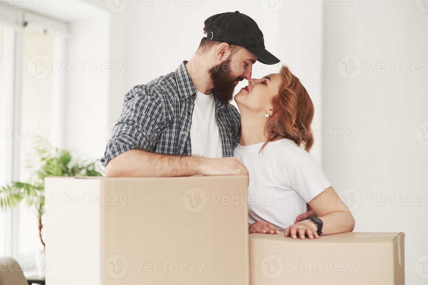 embrasse-moi. couple heureux ensemble dans leur nouvelle maison. conception du déménagement photo