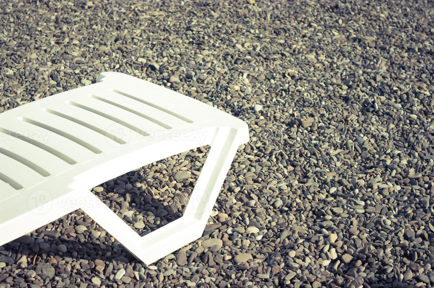 chaise de plage en plastique blanc sur le rivage. photo