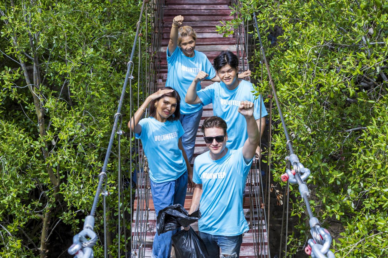 une équipe de jeunes et d'un groupe de travailleurs bénévoles de la diversité profite d'un travail social caritatif en plein air dans le cadre d'un projet de nettoyage des ordures dans la forêt de mangrove photo