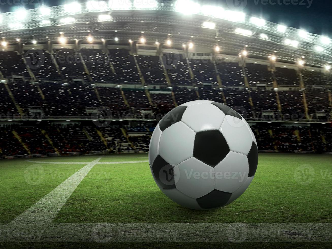 ballon de football sur le stade vert, arène dans la nuit éclairée par des projecteurs lumineux photo