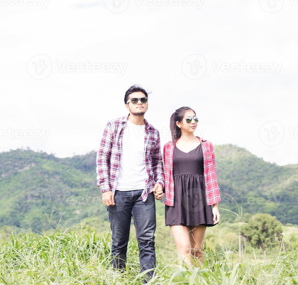 jeune couple hipster se tenant la main marchant sur le pré l'atmosphère relaxante et naturelle est très naturelle. photo