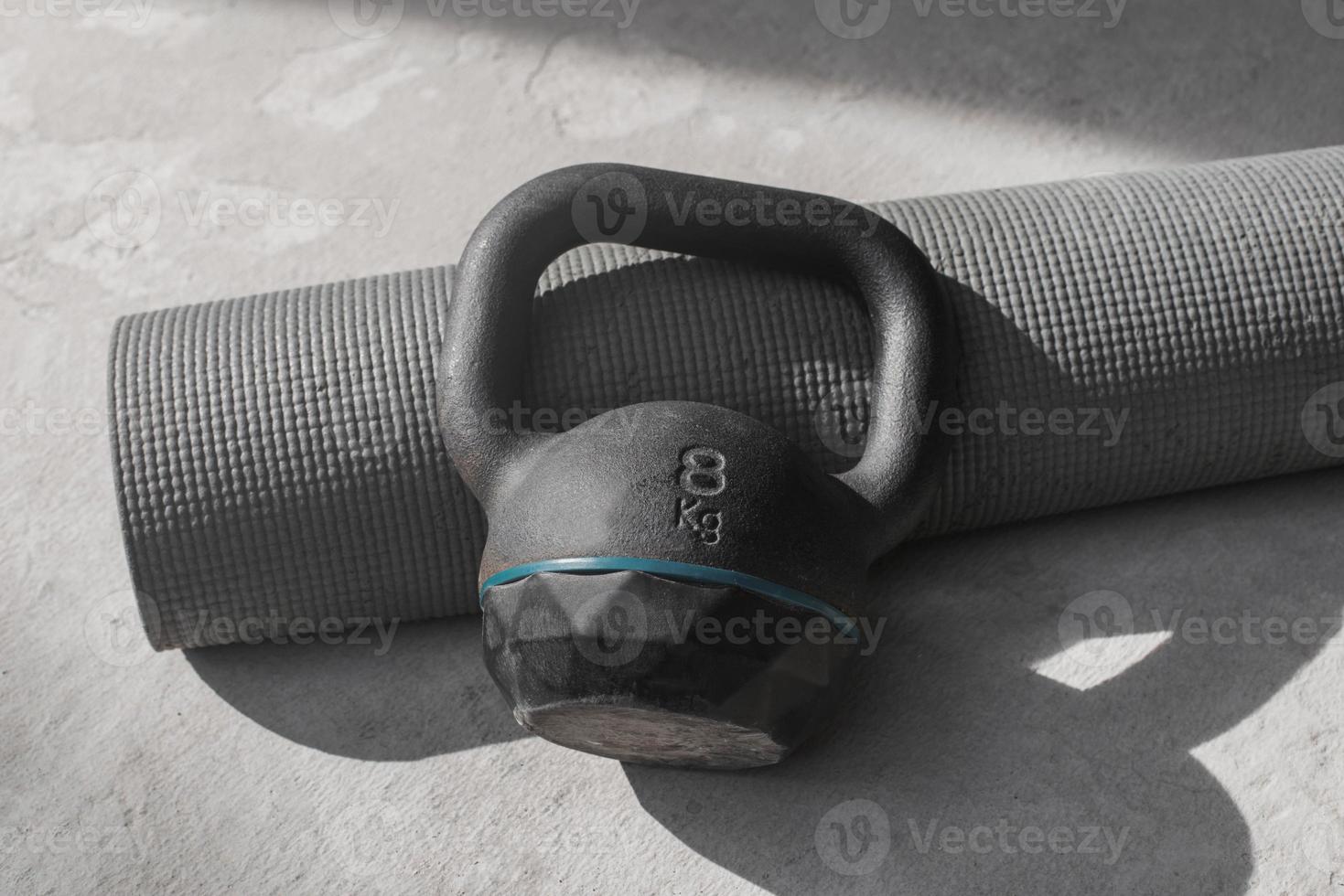 kettlebell et tapis de yoga sur le sol à la maison. équipement de gym. photo