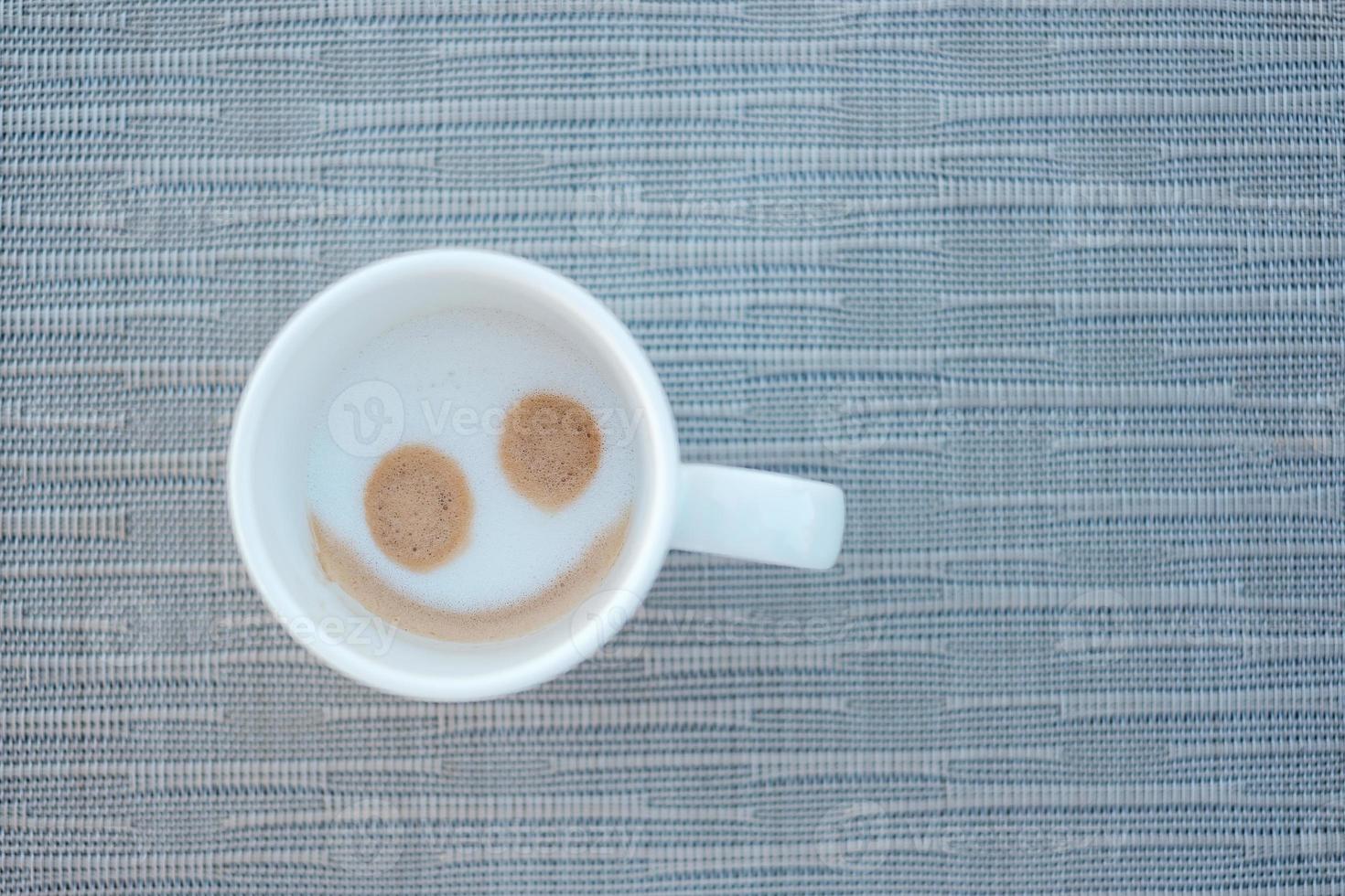 forme de visage souriant de café cappuccino chaud. passez une bonne journée photo