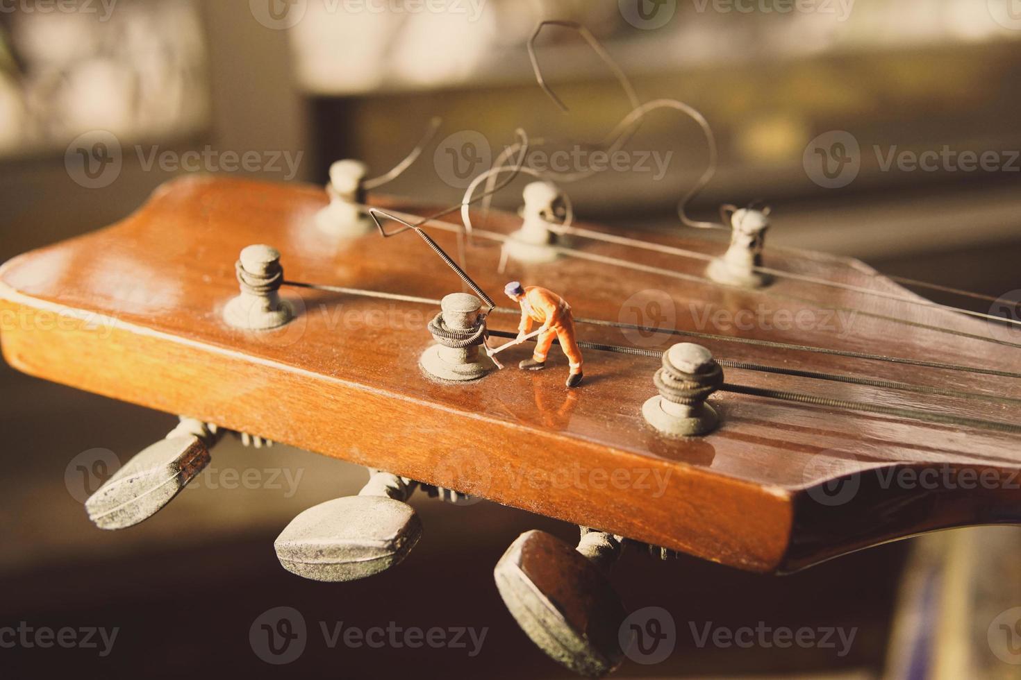 la figure du technicien qui répare les vieilles cordes de guitare. photo