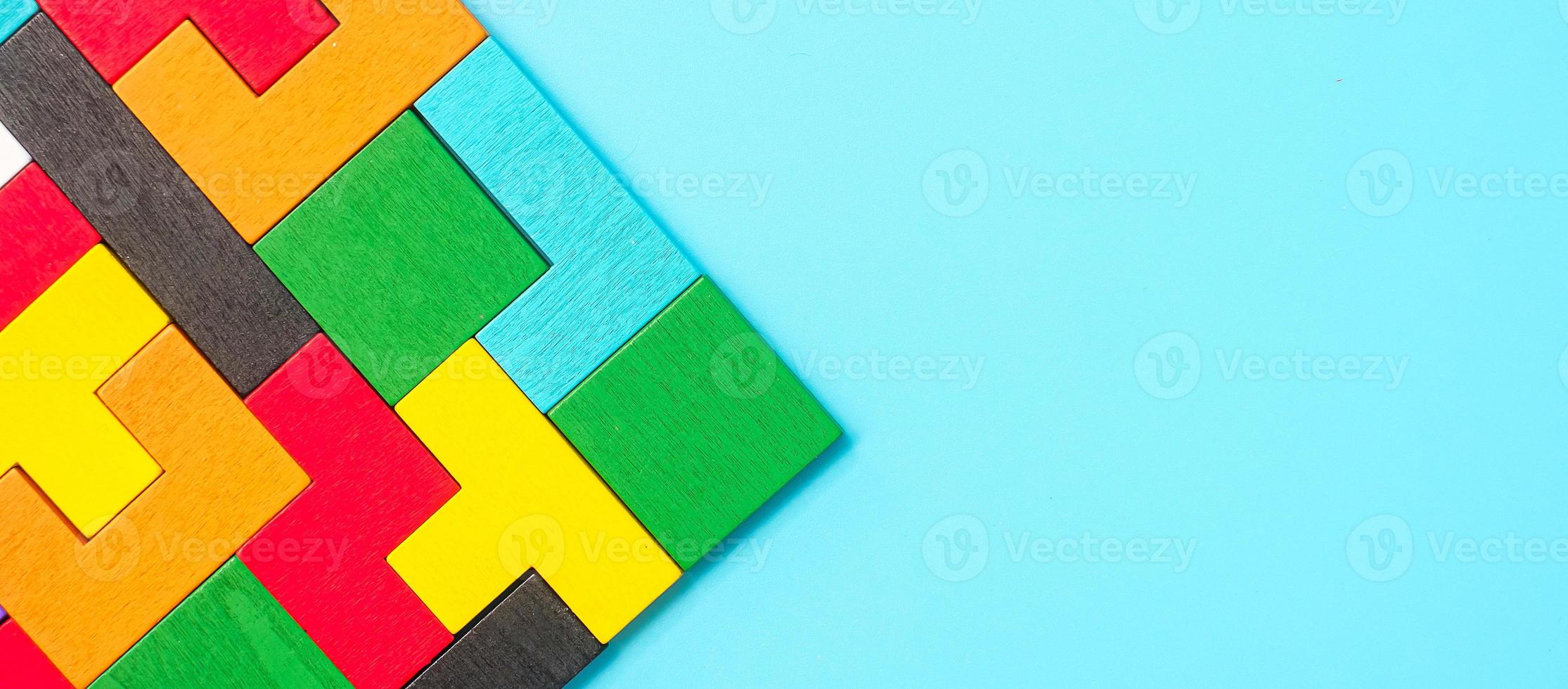 pièces de puzzle en bois colorées sur fond bleu, bloc de forme géométrique. concepts de pensée logique, énigme, solutions, rationnel, stratégie, journée mondiale de la logique et éducation photo