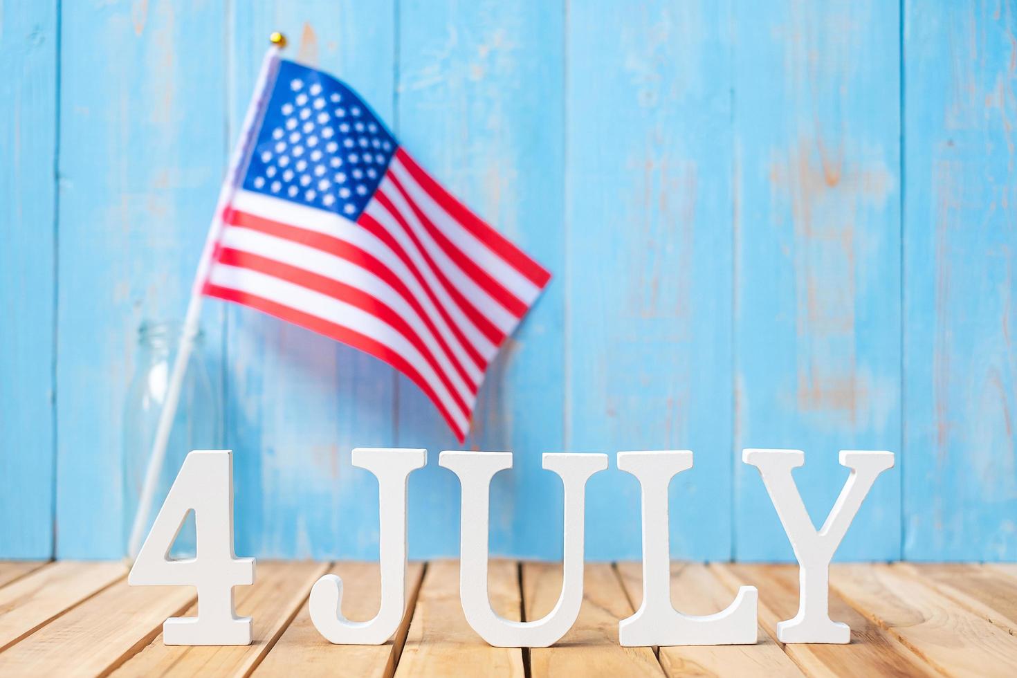 texte du 4 juillet et drapeau des états-unis d'amérique sur fond de table en bois. usa fête de l'indépendance et des concepts de célébration photo