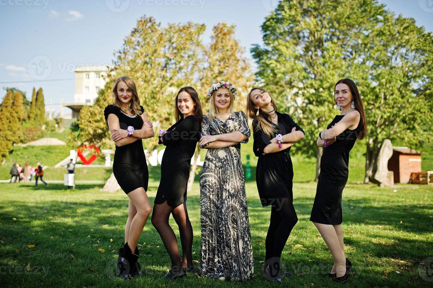 cinq filles portent du noir s'amusant à la fête de poule. photo