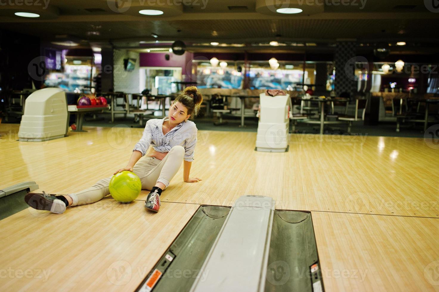 fille avec boule de bowling sur l'allée a joué au club de bowling. photo