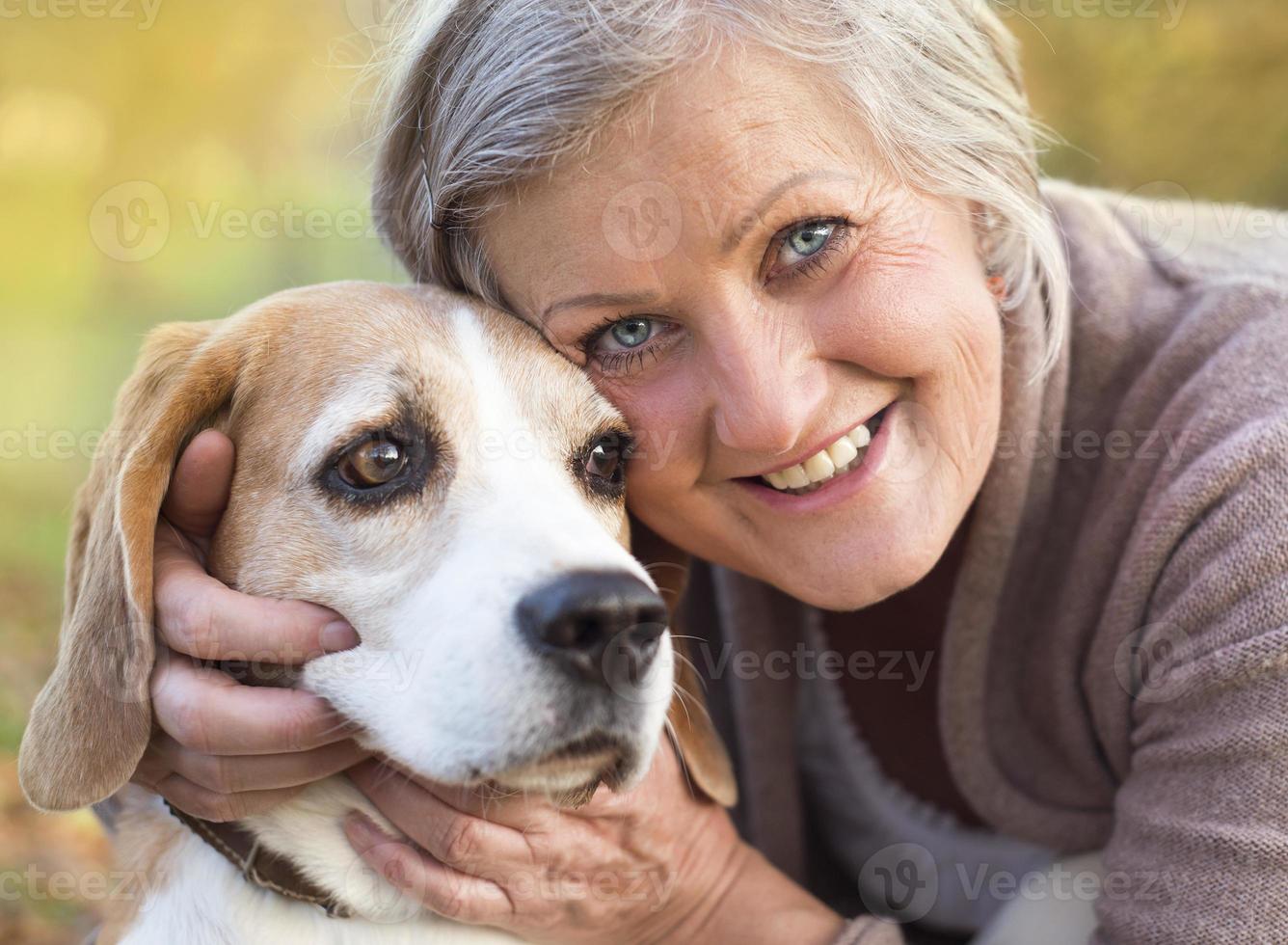 Active senior woman hugs dog photo