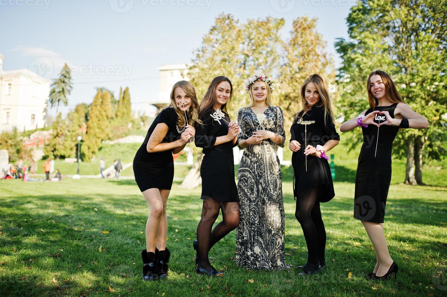 cinq filles portent du noir s'amusant à la fête de poule. photo