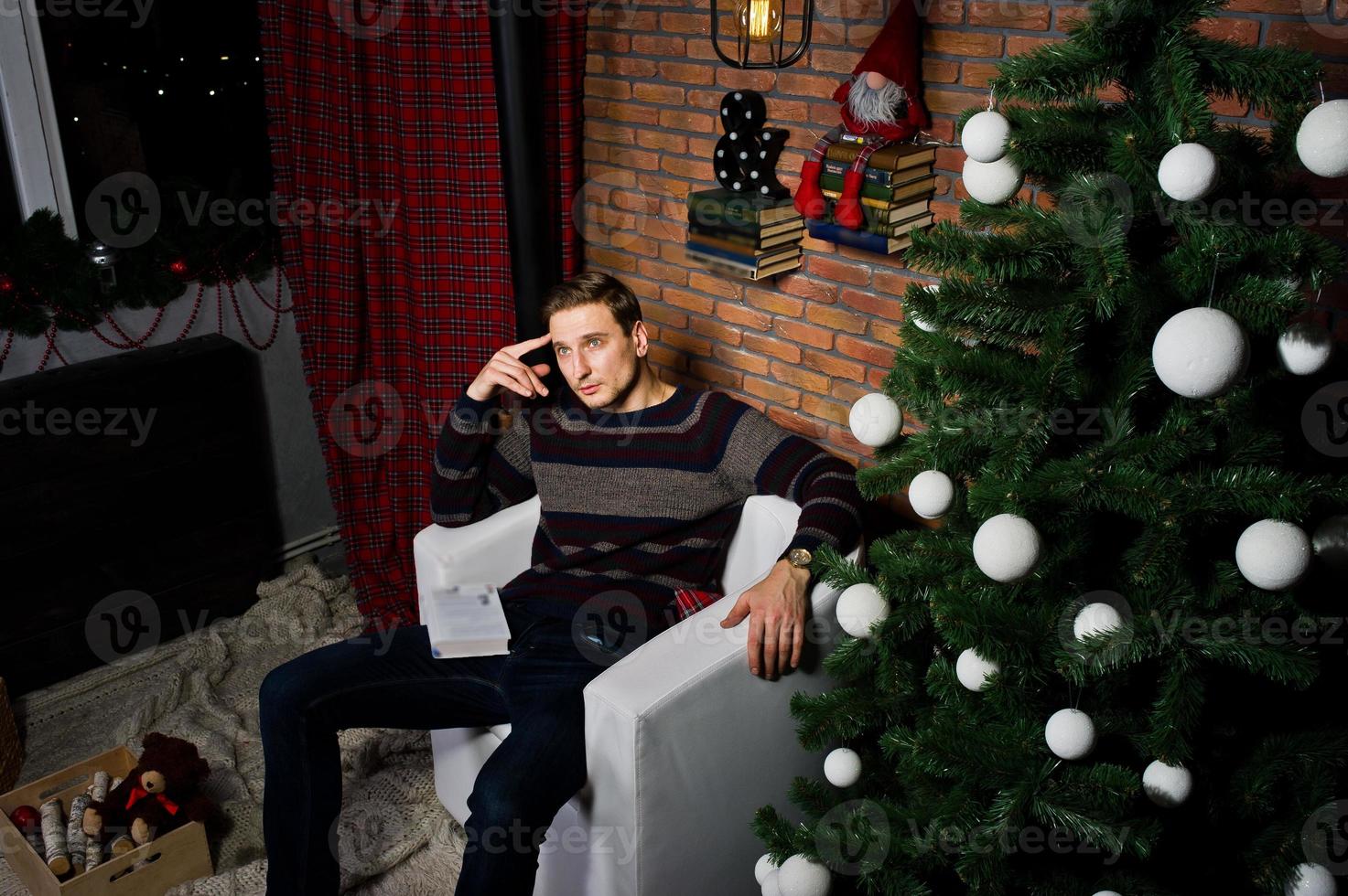 portrait en studio d'homme contre l'arbre de noël avec des décorations. photo