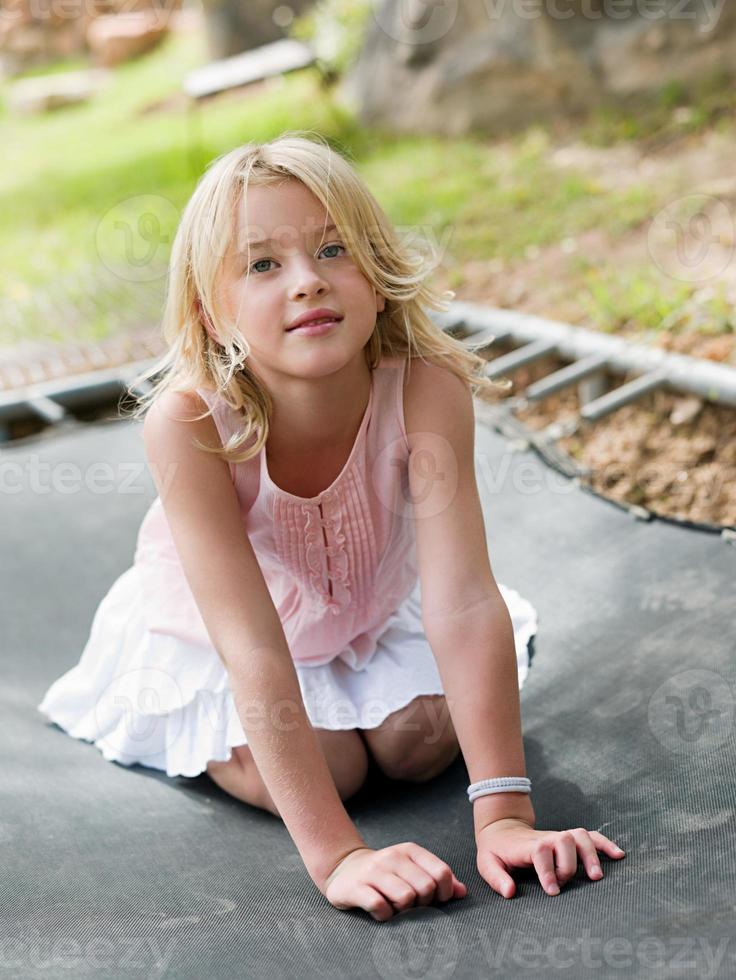 fille agenouillée sur trampoline photo