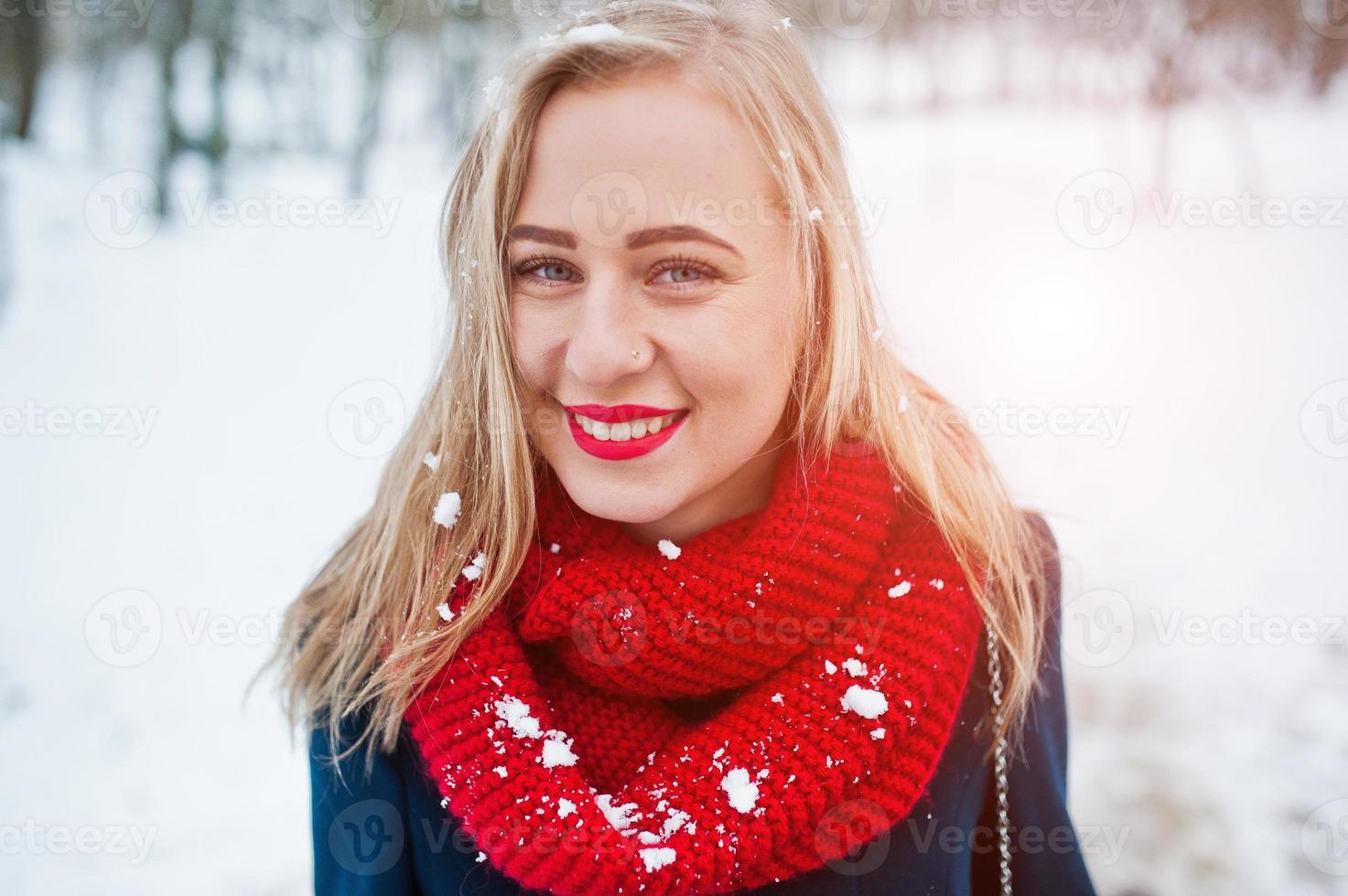 portrai de fille blonde en écharpe rouge et manteau le jour de l'hiver. photo